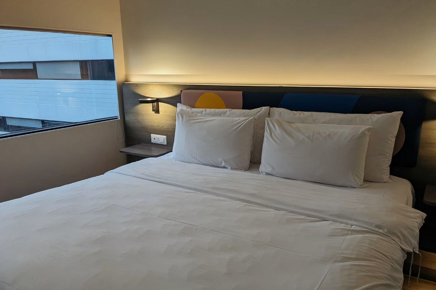 Chambre d'hôtel lumineuse, lit fait avec oreillers blancs